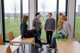 Kontakt Ein Gruppenfoto von Studierenden im Seminarraum mit dem TU Dortmund Logo. Sie sprechen miteinander und schauen sich an.